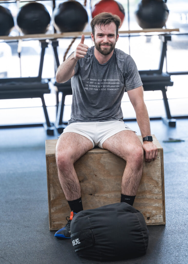 Man at gym giving thumbs up.