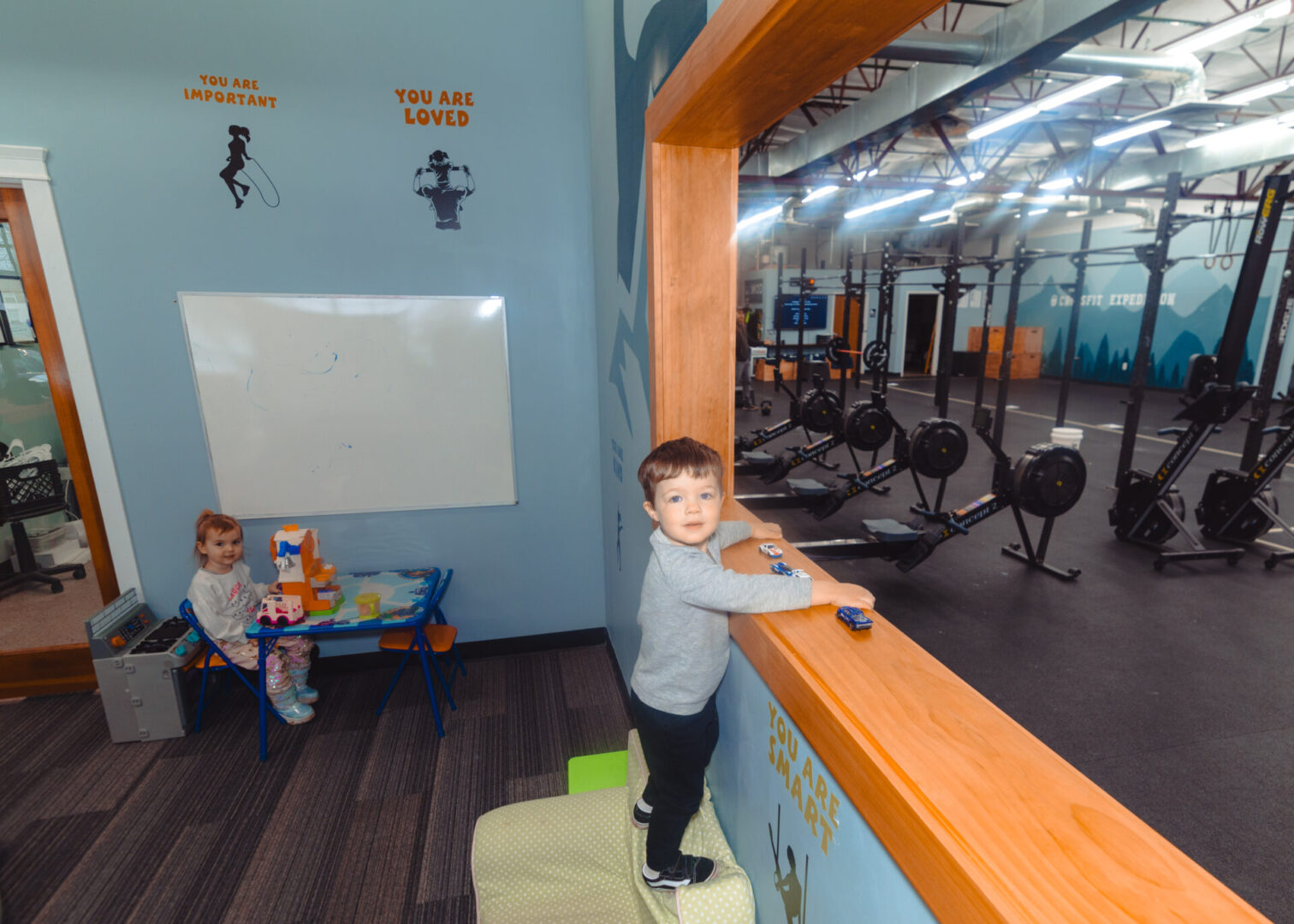 Toddler playing near gym window.