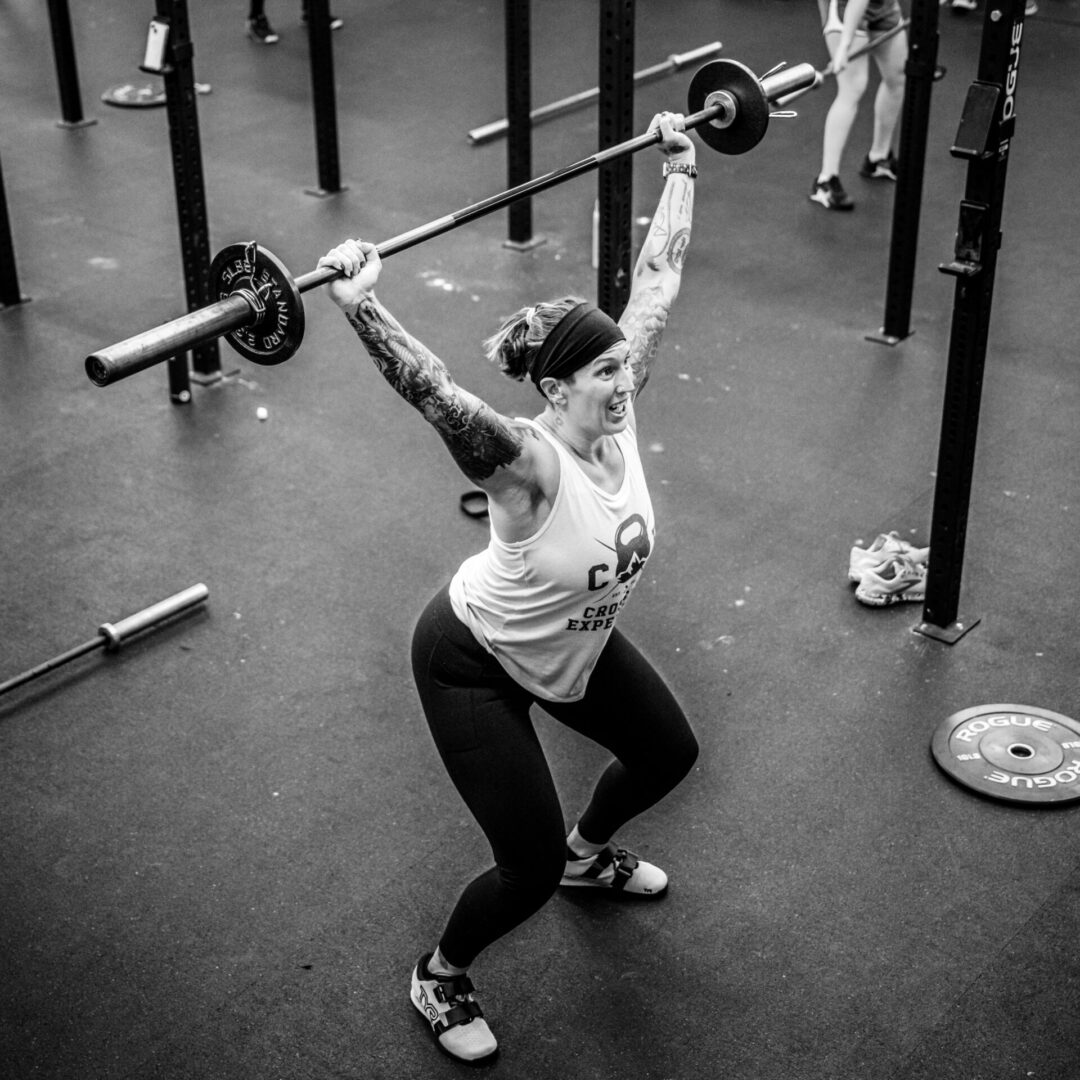 Woman performing overhead barbell lift.