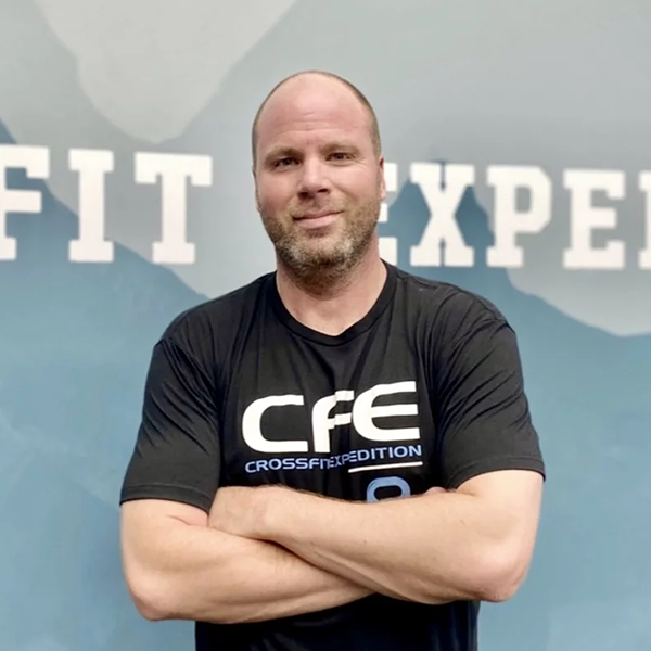 CrossFit Expedition coach with arms crossed.