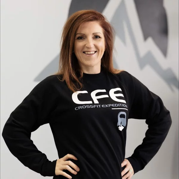 Woman smiling in CrossFit Expedition sweatshirt.